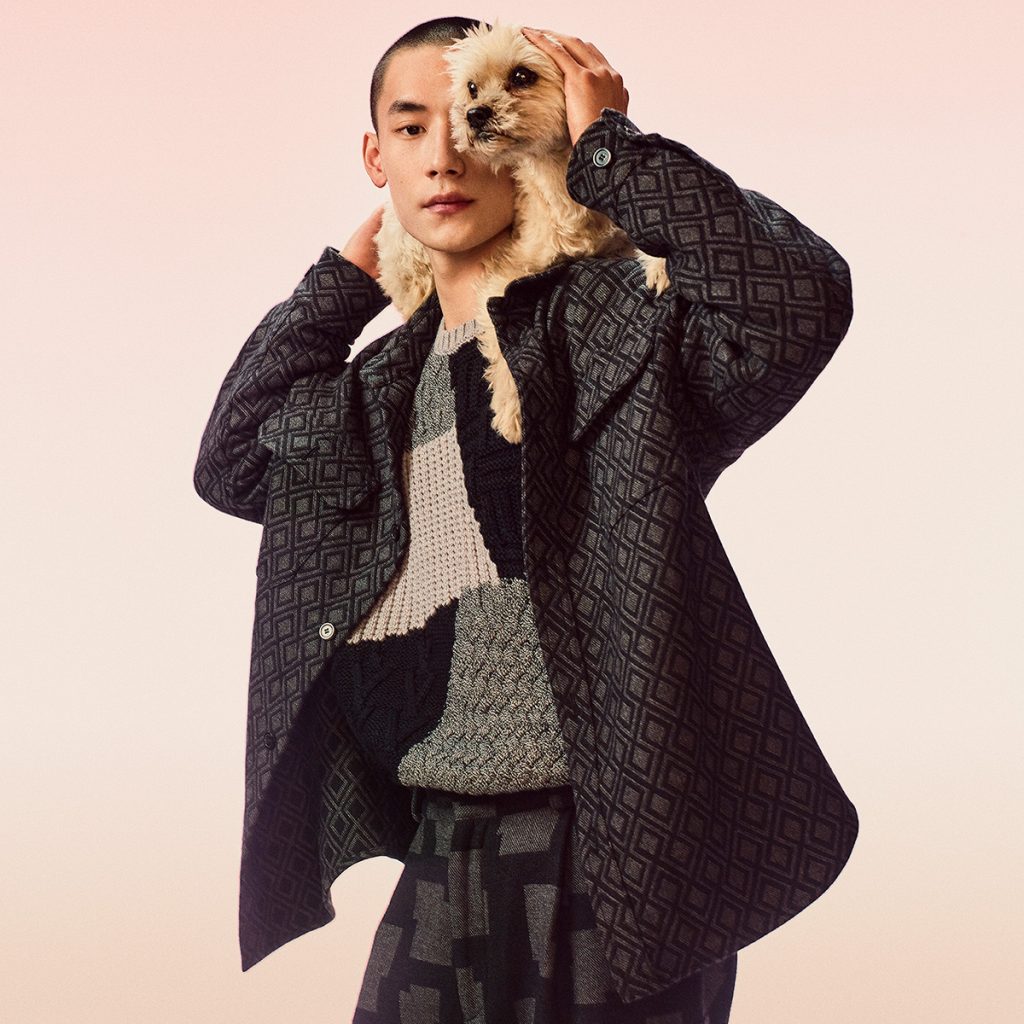 A man dressed in Emporio Armani with a small dog around his neck