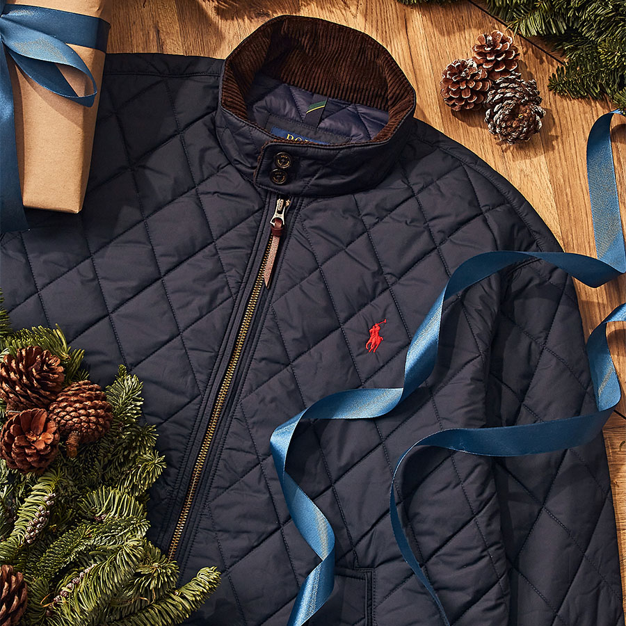 A barbour jacket among Christmas git wrapping and pine cones