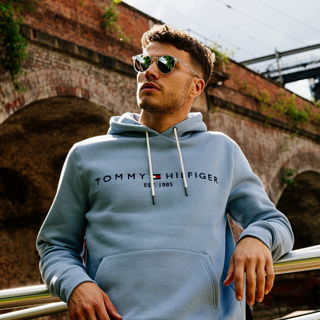 A man relaxing in the sun in a Tommy Hilfiger hoodie